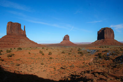 Scenic view of rock formations against blue sky