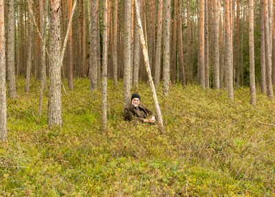 Portrait of man on grass in forest