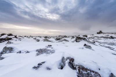 Snow covered landscape against sky