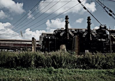 View of field against cloudy sky