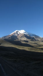 Scenic view of snowcapped mountains against clear blue sky
