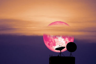 Low angle view of pink moon against sky during sunset