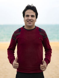 Portrait of young man standing on beach