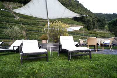 Empty chairs and table on field