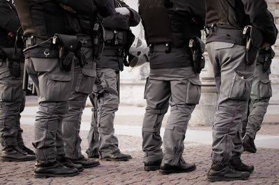 Low section of police men standing on footpath