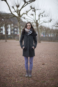 Full length portrait of woman standing in snow