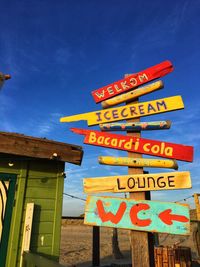 Low angle view of information sign against blue sky
