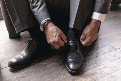 Businessman putting on shoes, tying shoelace