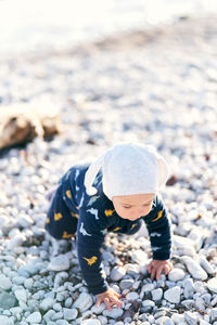 High angle view of boy on pebbles