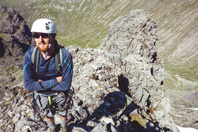 High angle view of hiker wearing helmets while climbing mountain