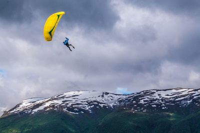 Low angle view of person paragliding against sky