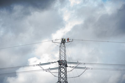 Low angle view of electricity pylon against sky