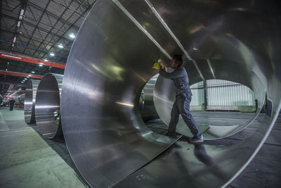 Worker examining metal in factory