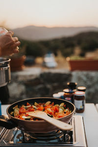 Cropped image of woman cooking vegetables in cooking pan