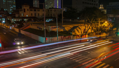 Light trails on road along buildings at night