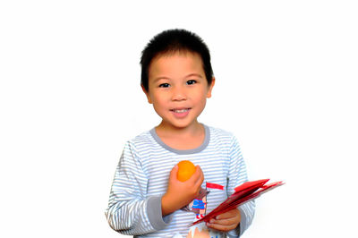 Portrait of boy holding baby against white background