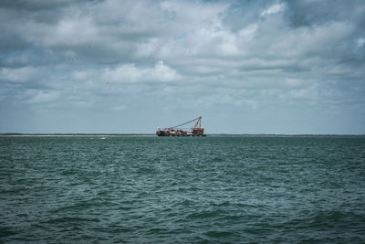 Ship sailing on sea against sky