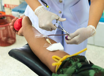 Close-up of nurse taking blood from patient in hospital