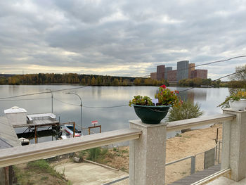 Scenic view of lake against sky in city