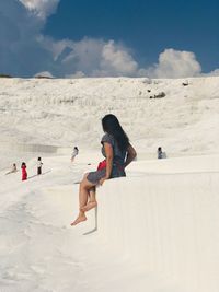 Woman sitting at travertine pool in pamukkale