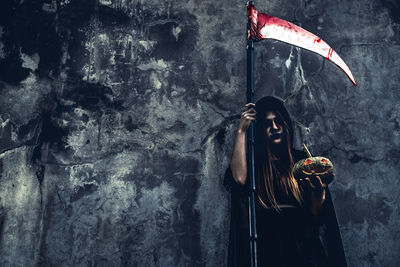 Digital composite image of woman standing against wall
