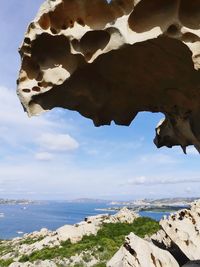 Close-up of rocks in sea against sky