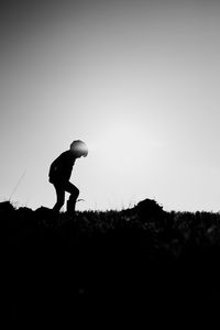 Silhouette man standing on field against sky