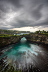 Scenic view of waterfall against sky