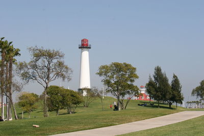 Lighthouse on field against clear sky