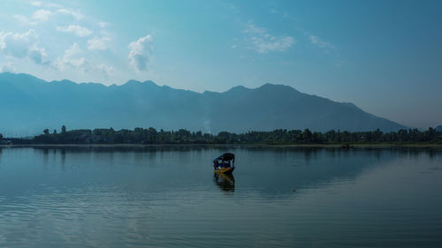 Man in boat on lake against sky