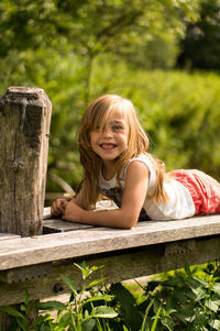 Portrait of smiling girl lying on pier