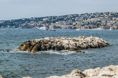 Scenic view of sea by buildings against sky