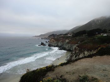 Scenic view of sea and mountains against sky