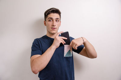 Portrait of young man standing against white background