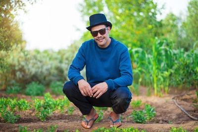 Portrait of young man sitting on field