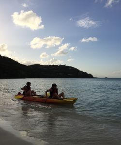 People in boat on lake against sky