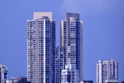 Low angle view of modern buildings against clear blue sky