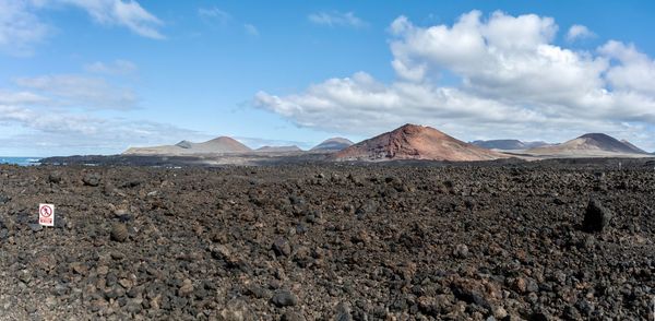 Scenic view of lava flow in lanzarote with warning sign