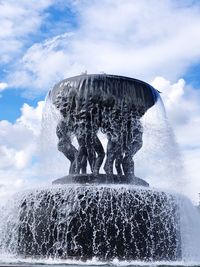 Fountain in winter against sky