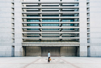 Rear view of woman walking on office building