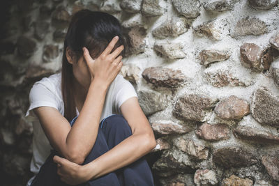 Low section of woman standing against wall