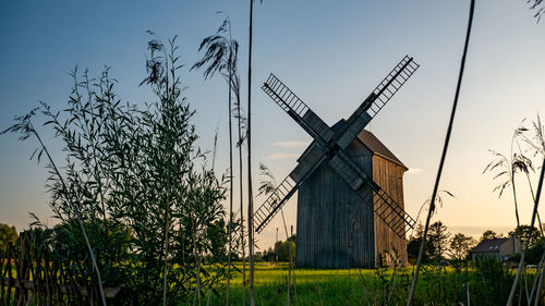 Traditional windmill on field against sky