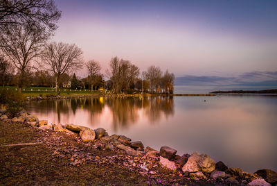 Scenic view of lake against sky at sunset