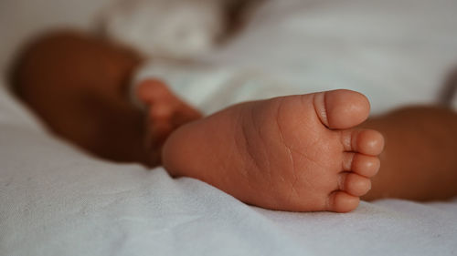 Close-up of baby lying on bed