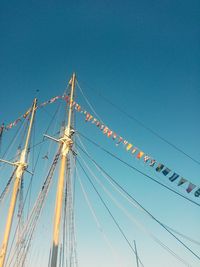 Low angle view of poles against clear blue sky