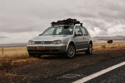 Car on road by land against sky