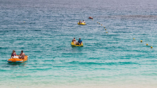 People sitting in boats on sea