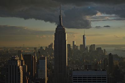 Modern buildings in city against sky during sunset