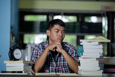 Portrait of young man sitting on table