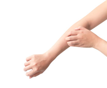 Close-up of woman hand with tattoo against white background